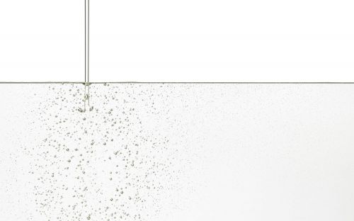 Effervescent water filling the frame, featuring tiny bubbles against a white background, clear and clean, perfect for visual backgrounds.