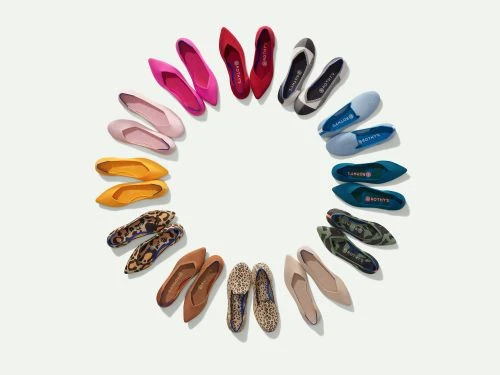 Overhead shot showcasing an array of colorful Rothy's ballet flats arranged in a circle on a clean, bright white background.