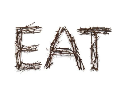 The word 'EAT' spelled out with thorny branches on a white background, creating a stark and somewhat unsettling visual.