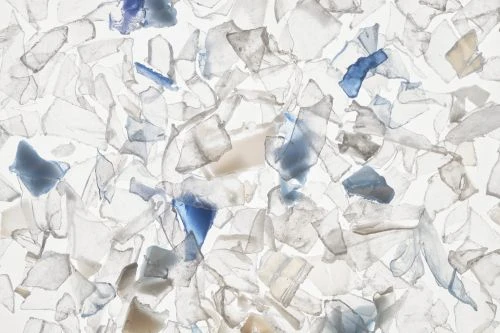 Scrap plastic pieces in varying shapes and sizes, mostly translucent white with some blue tint, filling the frame with a bright aesthetic.