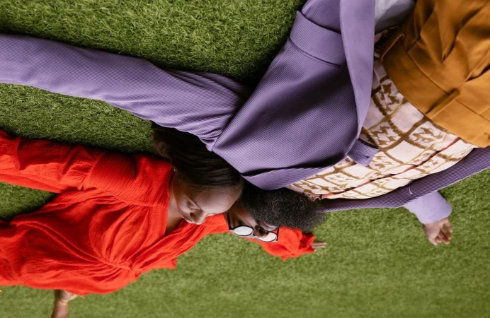 Two people lying on bright green artificial turf grass viewed from directly overhead by photographer Jimmy Marble.