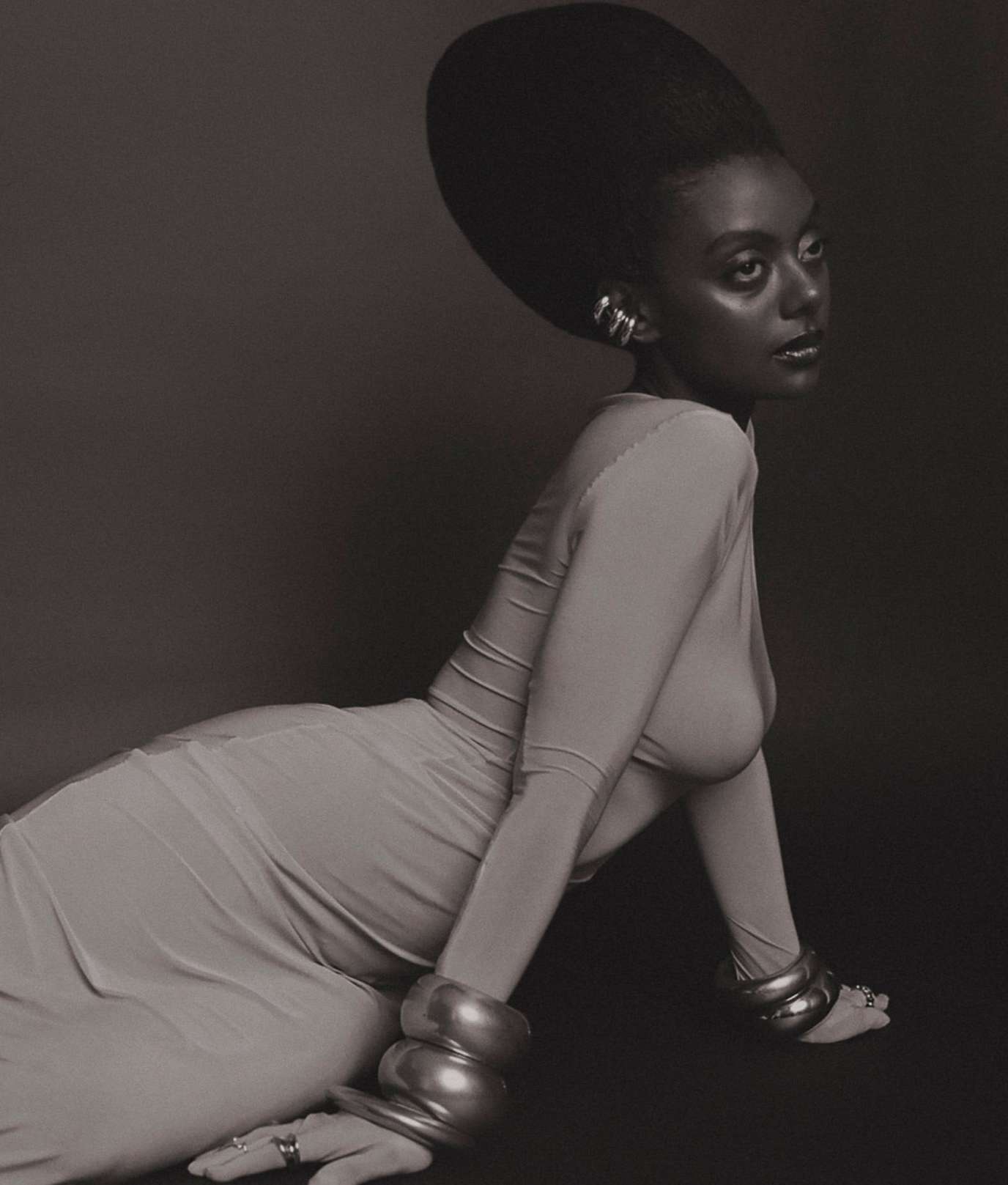 Portrait of a black woman with a large voluminous updo hairstyle wearing stacked metallic bracelets and cuffs in Los Angeles by Kendall Bessent