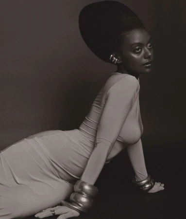 Portrait of a black woman with a large voluminous updo hairstyle wearing stacked metallic bracelets and cuffs in Los Angeles by Kendall Bessent