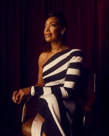 Elegant Black Woman in Striped Dress Seated Against Red Curtain Backdrop, Looking Upwards with Sophisticated Grace and Subtle Lighting.