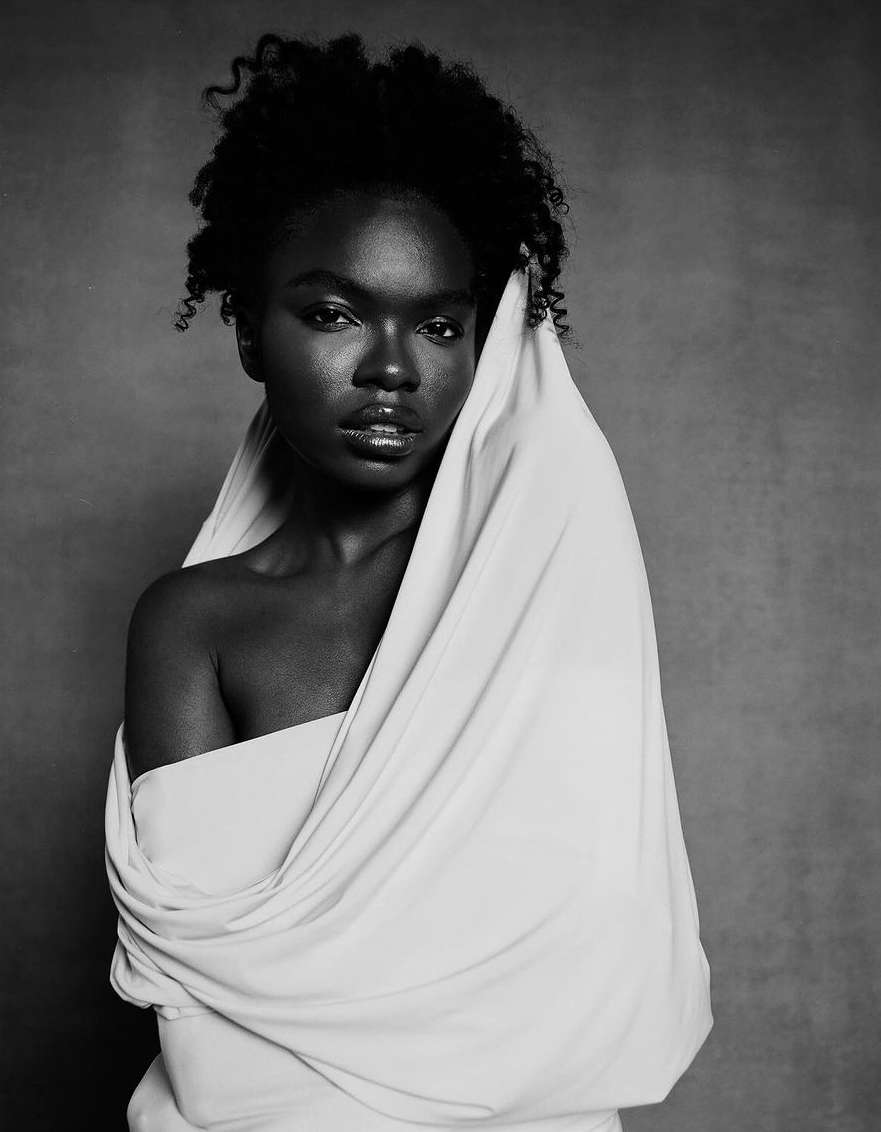 Monochrome portrait of a black woman draped in white fabric by photographer Kendall Bessent