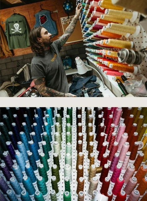 Man with tattoos reaching for colorful spools of thread on a rack. Display of thread with spools of colorful thread in a workshop setting.