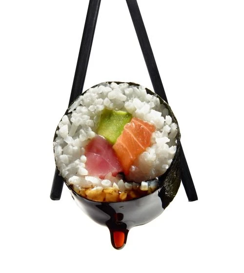 Macro studio shot of a sushi roll held by chopsticks with soy sauce dripping, against a white background, vibrant colors, and textures.