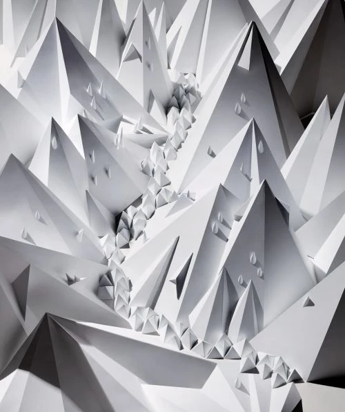 Abstract paper art featuring an array of geometric, triangular shapes and forms in shades of white, creating a visually stunning pattern.