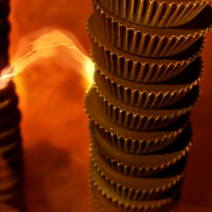 Stacked chocolate peanut butter cups on warm-toned backdrop create a visually appealing food still life with soft, diffused lighting.