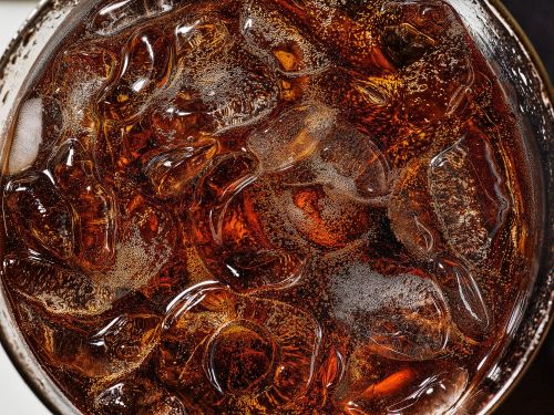 Close-up of a glass filled with a dark beverage and ice cubes, creating a refreshing and visually appealing image of a cold drink.