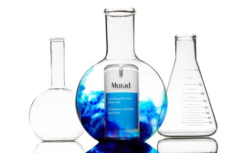 Murad clarifying oil-free water gel product in front of laboratory glassware with blue liquid for beauty and healthcare industries.