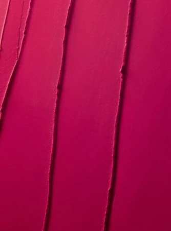 Close-up texture of bright pink lipstick or cosmetic cream, featuring vertical streaks and a smooth, vibrant surface.