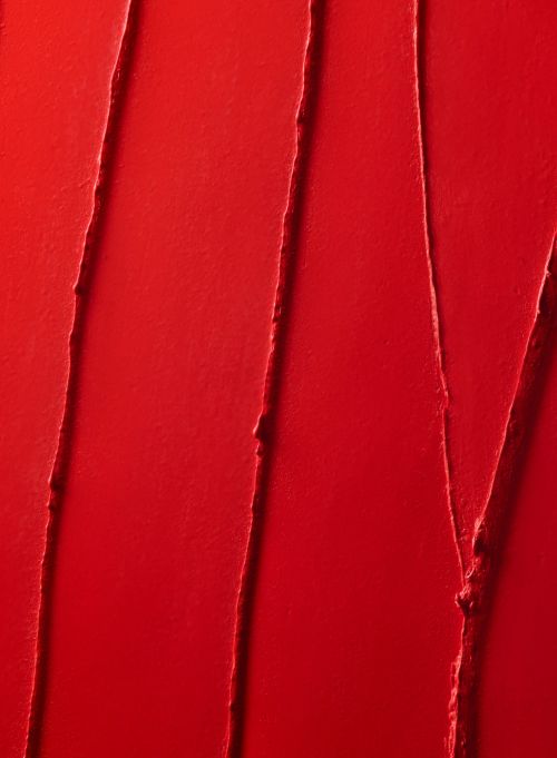 Close-up shot of red lipstick with linear textured swipes and glossy finish, ideal for beauty, makeup, or cosmetic product promotion.