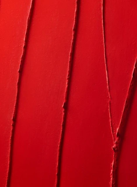 Close-up shot of red lipstick with linear textured swipes and glossy finish, ideal for beauty, makeup, or cosmetic product promotion.