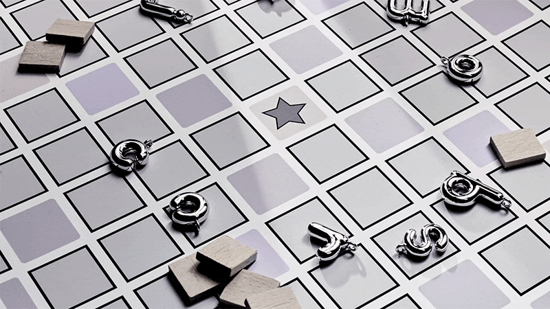 Overhead shot of a board game with a grid pattern, wooden tile pieces, and metal charms scattered across the surface.