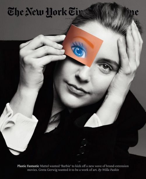 Black and white portrait of Greta Gerwig on New York Times cover, holding a Barbie eye graphic over her eye, wearing a dark jacket.