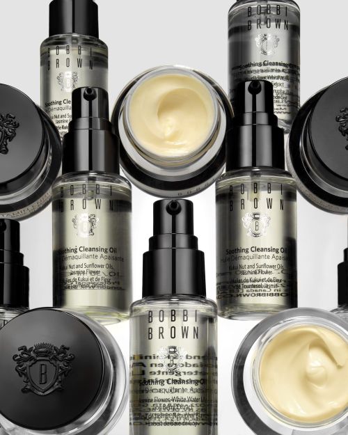 Bobbi Brown skincare product arrangement featuring cleansing oils and creams in clear bottles and jars with black lids and labeling.