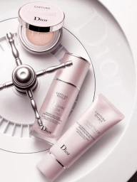 Three Dior Capture Totale skincare products arranged on a circular white surface with a decorative metallic valve handle.
