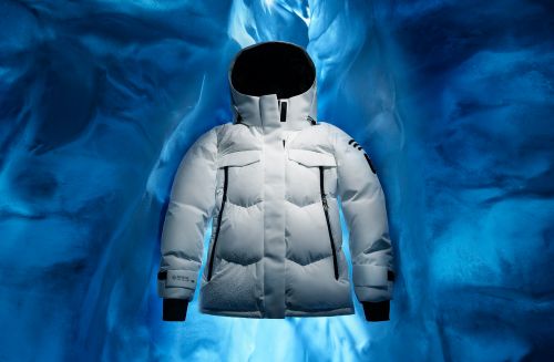 White hooded down jacket on blue background. Padded and puffy winter outwear. Winter fashion and apparel for outdoor activities.