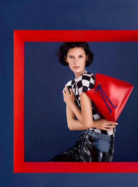Stylish woman in a black-and-white checkered top poses with a red purse against a navy blue background framed in red.