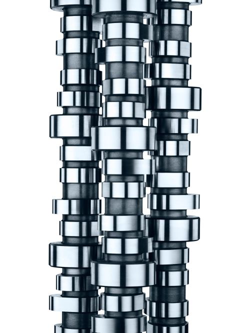 Close-up of three camshafts arranged vertically, highlighting the intricate design and metallic finish against a white backdrop.
