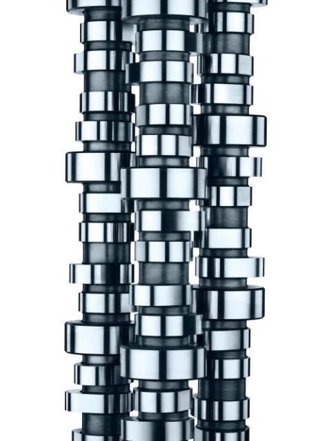 Close-up of three camshafts arranged vertically, highlighting the intricate design and metallic finish against a white backdrop.