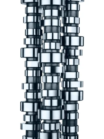 Close-up of three camshafts arranged vertically, highlighting the intricate design and metallic finish against a white backdrop.