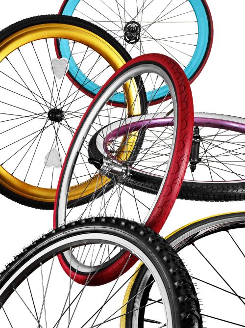 Dynamic studio shot of multiple bicycle wheels with colorful tires, spokes, and hubs against a clean white backdrop creating visual interest.