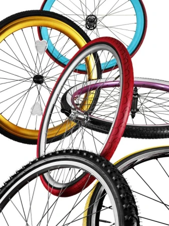 Dynamic studio shot of multiple bicycle wheels with colorful tires, spokes, and hubs against a clean white backdrop creating visual interest.