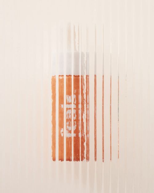 Minimalist studio shot of an orange bottle with vertical white lines, clean background, product photography, focus on texture and color.