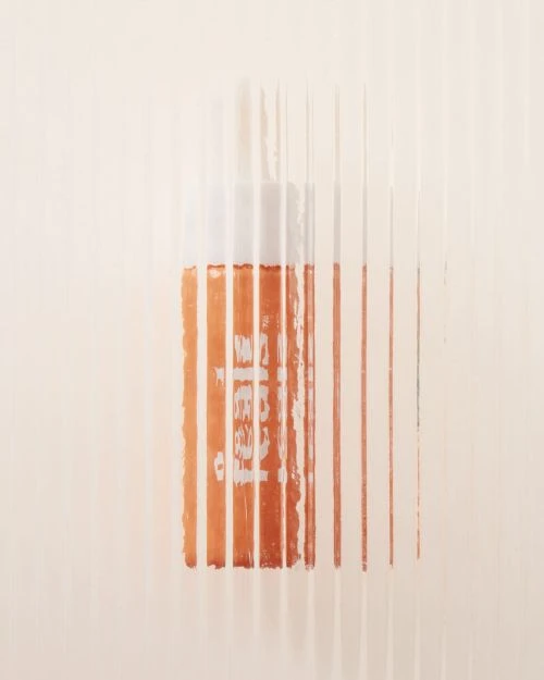 Minimalist studio shot of an orange bottle with vertical white lines, clean background, product photography, focus on texture and color.