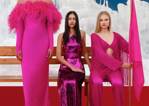 Three women in pink dresses pose on a bench against an icy backdrop. The dresses feature different styles, including feather accents and sequins.