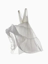 A white sheer dress floating mid-air against a seamless plain background, captured with dynamic motion.