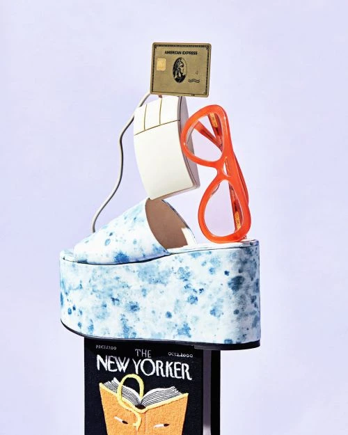 Whimsical composition featuring a platform shoe, computer mouse, eyeglasses, credit card, and magazine on a white gradient background.