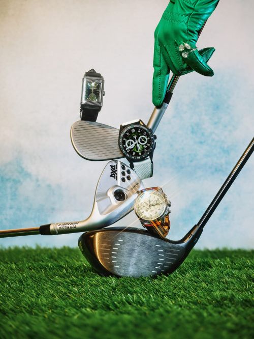 Stacked golf clubs and wrist watches. Green gloved hand at the top. Sky and grass background. Sport, fashion, and leisure concept.
