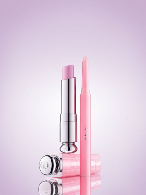 Close-up studio shot of pink Dior lip products: a balm and a lip liner, showcased against a soft pastel background for beauty advertising.