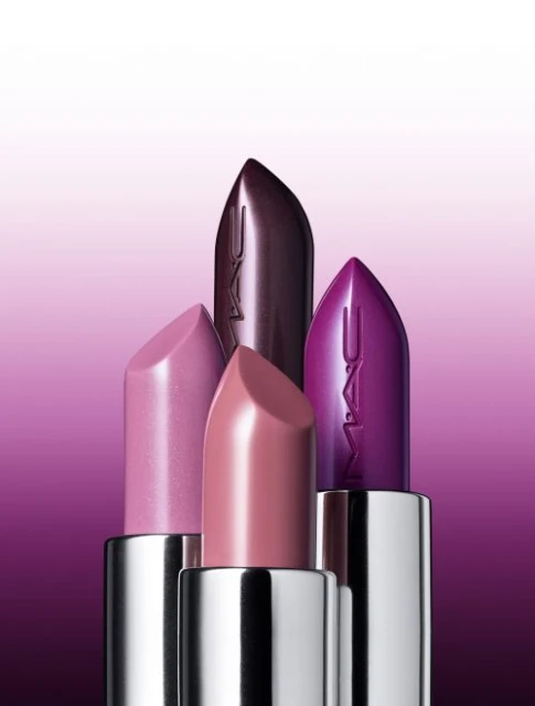 Four MAC lipsticks in pink, mauve, purple, and plum colors are displayed against a gradient background from white to purple.
