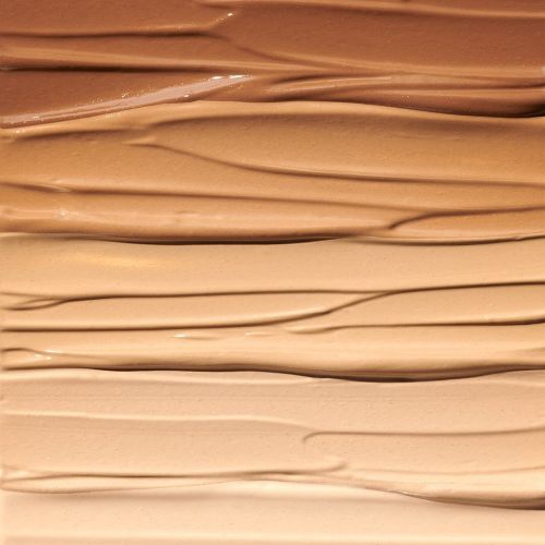 Close-up of cosmetic foundation swatches in various shades of beige, tan, and brown, showcasing smooth textures for beauty product marketing.
