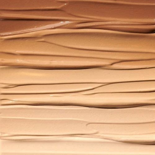 Close-up of cosmetic foundation swatches in various shades of beige, tan, and brown, showcasing smooth textures for beauty product marketing.