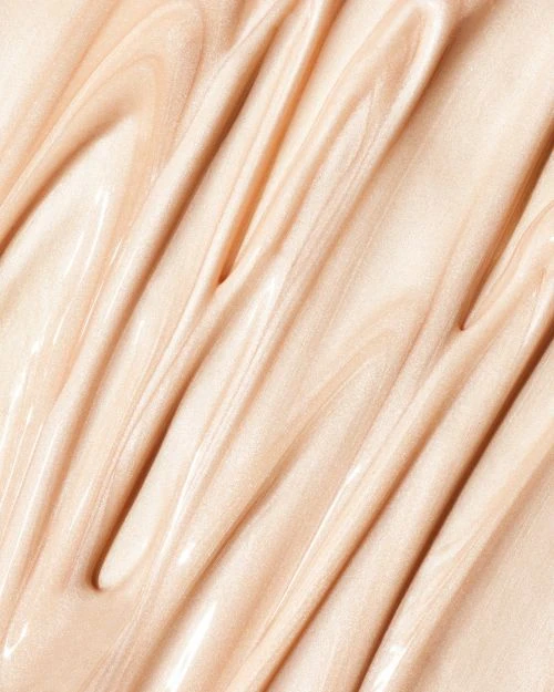 Close-up of swirling beige liquid cosmetic, creating a glossy and textured surface. Ideal for beauty or skincare product backgrounds.