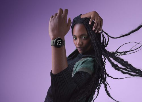 Portrait of a Black woman with long braids and a smartwatch against a purple background, focusing on fashion and wearable technology.