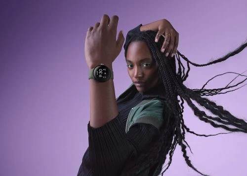 Portrait of a Black woman with long braids and a smartwatch against a purple background, focusing on fashion and wearable technology.