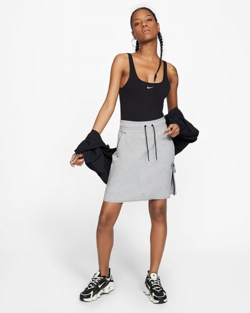 Black woman wearing a black tank top and grey skirt with a black jacket styled by Leah Adicoff