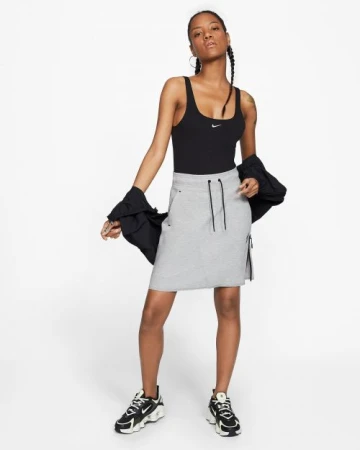 Black woman wearing a black tank top and grey skirt with a black jacket styled by Leah Adicoff