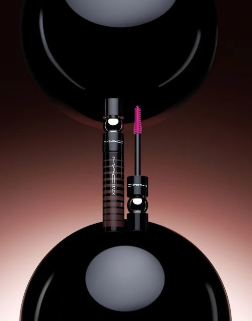 MACStack mascara product shot with black tubes, a pink brush, and spherical black background elements for beauty advertising.