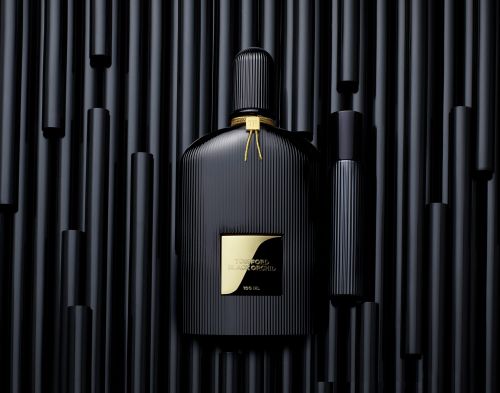 Black Ford Orchid perfume bottle with an atomizer on a background of black vertical tubes creating a dark, luxurious, and stylish presentation.