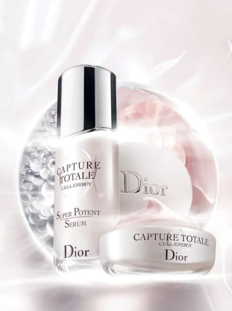 Dior skincare products, including serum and cream, are displayed against a softly lit background featuring a floral motif.
