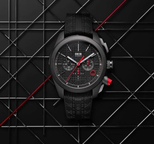Luxury black wristwatch with red accents on a matching strap displayed on a dark geometric surface for a high-end fashion advertisement.