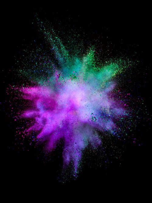 Abstract burst of purple, teal, and green powder against a black background; a dynamic and vibrant explosion of colors.