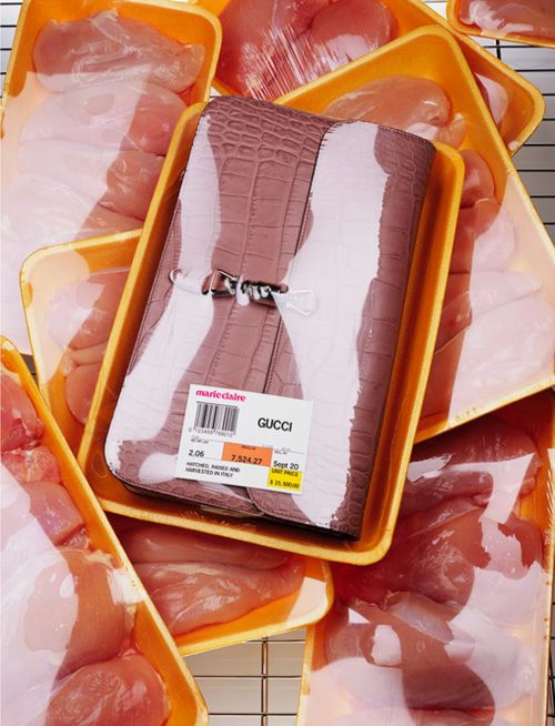 Gucci handbag in a yellow plastic tray surrounded by packages of raw chicken breast, fashion editorial or juxtaposition.